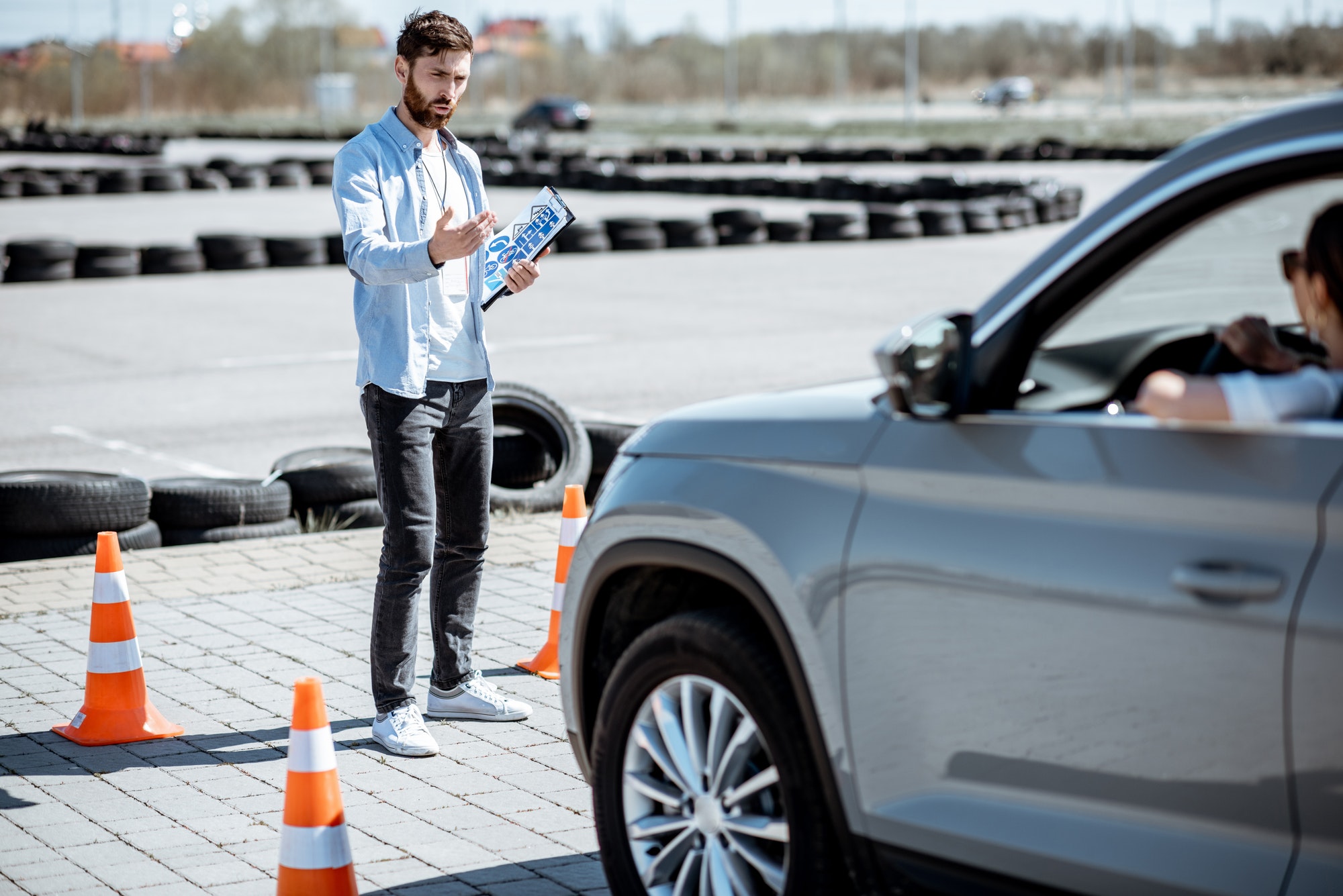 Instructor teaching to drive a car on the training ground